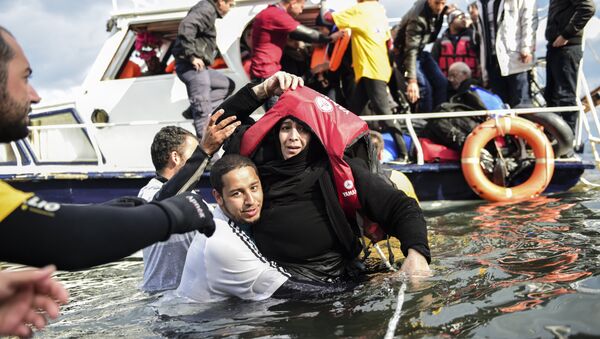 Migrant families - helped by rescuers - disembark on the Greek island of Lesbos after crossing with other migrants and refugees the Aegean Sea from Turkey, on November 25, 2015. - Sputnik International