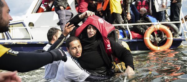 Migrant families - helped by rescuers - disembark on the Greek island of Lesbos after crossing with other migrants and refugees the Aegean Sea from Turkey, on November 25, 2015. - Sputnik International