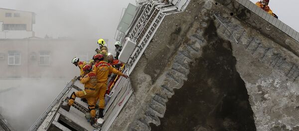 Rescue personnel work at the site where a 17-storey apartment building collapsed, after an earthquake in Tainan, southern Taiwan, February 6, 2016 - Sputnik International
