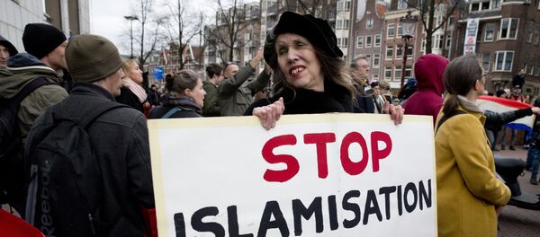 A woman holds a placard during a Pegida demonstration against immigration and islamization in Amsterdam, Netherlands - Sputnik International