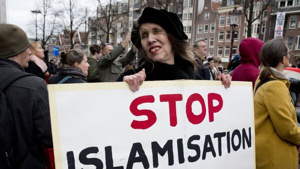 A woman holds a placard during a Pegida demonstration against immigration and islamization in Amsterdam, Netherlands - Sputnik International
