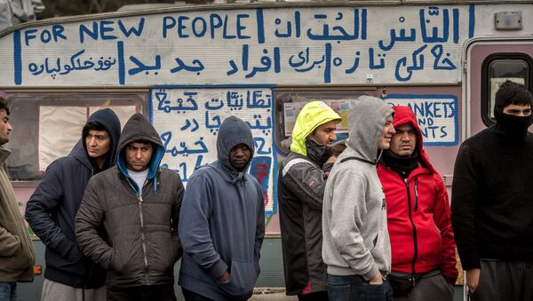 Refugees stand in the so-called Jungle migrant camp in Calais, northern France - Sputnik International
