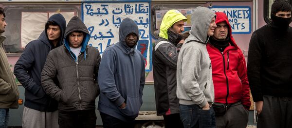 Refugees stand in the so-called Jungle migrant camp in Calais, northern France - Sputnik International