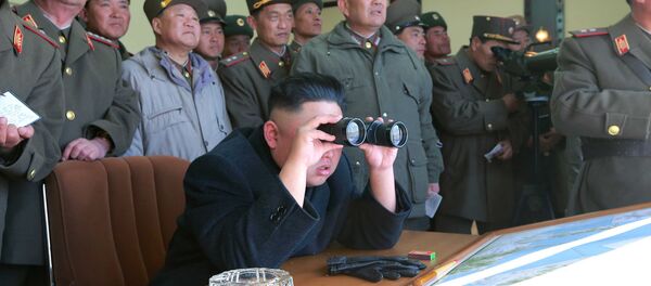 North Korean leader Kim Jong Un uses a pair of binoculars to watch live ammunition firing drills. - Sputnik International