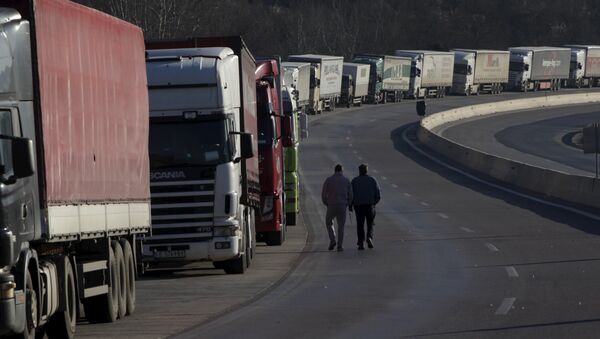 Truck drivers walk next to parked trucks as protesting farmers (not pictured) block the road leading to the border station of Greece with Bulgaria during a demonstration against planned pension reforms near the Greek village of Promachonas. - Sputnik International