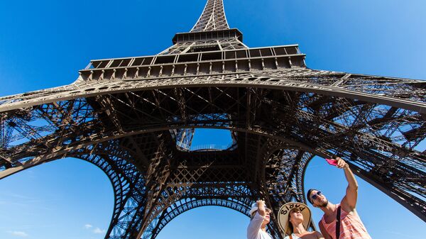 People taking a selfie in front of the Eiffel Tower, Paris. - Sputnik International