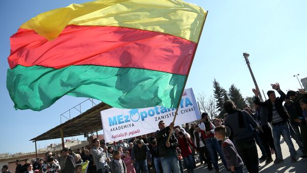 A Kurdish man waves a large flag of the Kurdish People's Protection Units (YPG) political wing, the Democratic Union Party (PYD), during a demonstration against the exclusion of Syrian-Kurds from the Geneva talks in the northeastern Syrian city of Qamishli on February 4, 2016 - Sputnik International
