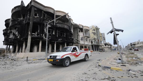 This file photo taken on October 24, 2011 shows Libyans driving through a destroyed neighbourhood in Sirte - Sputnik International
