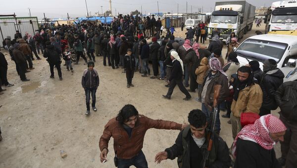 Syrians gather at the Bab al-Salam border gate with Turkey, in Syria, Saturday, Feb. 6, 2016 - Sputnik International