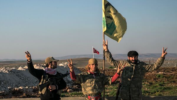 FILE - In this Sunday, Feb. 22, 2015, file photo, Syrian Kurdish militia members of YPG make a V-sign next to poster of Abdullah Ocalan, jailed Kurdish rebel leader, and a Turkish army tank in the background in Esme village in Aleppo province, Syria - Sputnik International