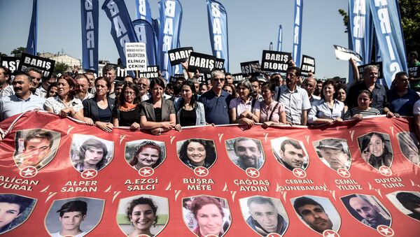 Protesters and members of Turkey's People's Democracy Party (HDP) hold a banner with pictures of the victims of the Suruc bomb attack after their peace march was banned by authorities in the Aksaray district of Istanbul on July 26 - Sputnik International