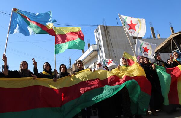 Kurdish women hold flags of the Kurdish People's Protection Units (YPG) political wing, the Democratic Union Party (PYD), and banners during a demonstration against the exclusion of Syrian-Kurds from the Geneva talks in the northeastern Syrian city of Qamishli on February 4, 2016 Kurdish women hold flags of the Kurdish People's Protection Units (YPG) political wing, the Democratic Union Party (PYD), and banners during a demonstration against the exclusion of Syrian-Kurds from the Geneva talks in the northeastern Syrian city of Qamishli on February 4, 2016 - Sputnik International