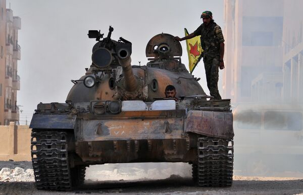 Fighters from the Kurdish People's Protection Units (YPG) drive a tank in the al-Zohour neighbourhood of northeastern Syrian city of Hasakeh (File) - Sputnik International