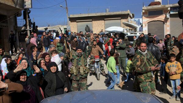 Residents of Nubul and al-Zahraa, along with forces loyal to Syria's President Bashar al-Assad, celebrate after the siege of their towns was broken, northern Aleppo countryside, Syria, in this handout picture provided by SANA on February 4, 2016 - Sputnik International
