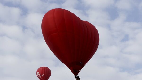 A heart-shaped hot air balloon (R) flies in the sky during the Love Cup 2016 event, ahead of Valentine's Day, in Jekabpils, Latvia, February 13, 2016 - Sputnik International