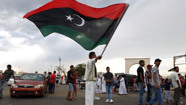 A Libyan man waves his national flag - Sputnik International