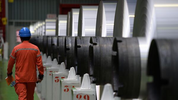 An employee walks along aluminium rolls at the Constellium factory, on December 12, 2014 in Biesheim, eastern France. - Sputnik International