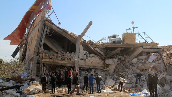 People gather around the rubble of a hospital supported by Doctors Without Borders (MSF) near Maaret al-Numan, in Syria's northern province of Idlib, on February 15, 2016 - Sputnik International