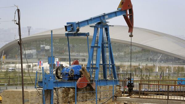 The Baku Aquatics Centre, one of the venues of the 2015 European Games stands in the background, as an oil pump works a nearby field in Baku, Azerbaijan. - Sputnik International