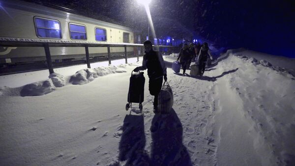 Refugees disembark and make their way to a camp at a hotel touted as the world's most northerly ski resort in Riksgransen, Sweden, in this December 15, 2015 file photo. - Sputnik International