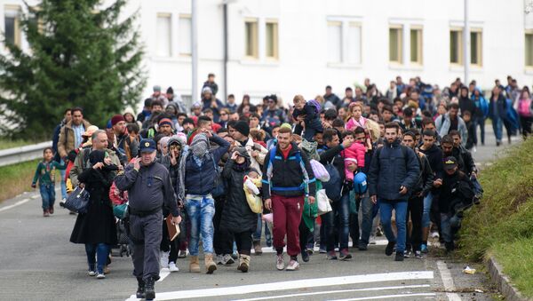 Migrants and refugees across the Slovenian-Austrian border in Sentilj towards Spielfeld on October 18, 2015. - Sputnik International