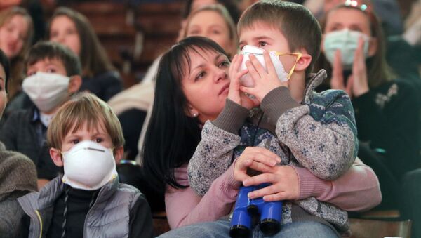 Children in face masks watch a performance at the circus, in the Ukrainian capital Kiev Thursday, Jan. 21, 2016 - Sputnik International
