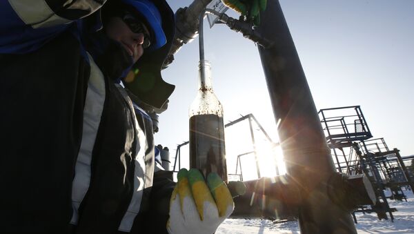 A worker takes oil samples from a well at the Gazpromneft company owned Yuzhno-Priobskoye oil field outside the West Siberian city of Khanty-Mansiysk, Russia, January 28, 2016 - Sputnik International