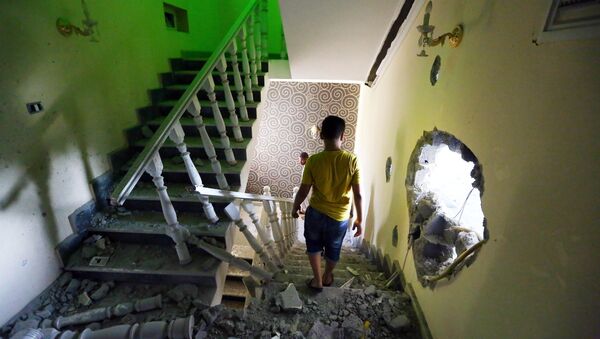 A youth walks down the stairs near a hole in the wall of a house at a former Libyan army camp known as Camp 27, in the Libyan capital Tripoli (File) - Sputnik International