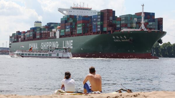 Two people sit on the beach and watch the CSCL Mars container ship of the China Shipping company (File) - Sputnik International