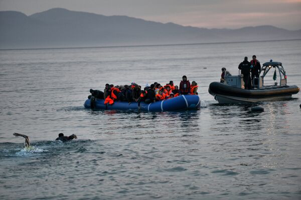 Refugees and migrants massed onto an inflatable boat reach Mytilene, northern island of Lesbos, after crossing the Aegean sea from Turkey on February 17, 2016 Refugees and migrants massed onto an inflatable boat reach Mytilene, northern island of Lesbos, after crossing the Aegean sea from Turkey on February 17, 2016 - Sputnik International