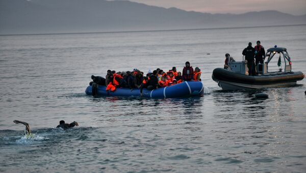 Refugees and migrants massed onto an inflatable boat reach Mytilene, northern island of Lesbos, after crossing the Aegean sea from Turkey on February 17, 2016 - Sputnik International