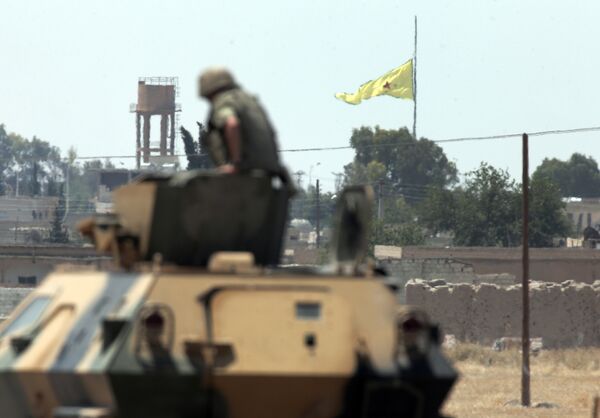 In this photo taken from the Turkish side of the border between Turkey and Syria, in Akcakale, southeastern Turkey, a Turkish soldier on an armoured personnel carrier watches as in the background a flag of the Kurdish People's Protection Units, or YPG, is raised over the city of Tal Abyad, Syria, Tuesday, June 16, 2015 In this photo taken from the Turkish side of the border between Turkey and Syria, in Akcakale, southeastern Turkey, a Turkish soldier on an armoured personnel carrier watches as in the background a flag of the Kurdish People's Protection Units, or YPG, is raised over the city of Tal Abyad, Syria, Tuesday, June 16, 2015 - Sputnik International