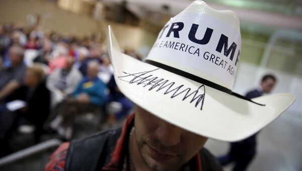 A campaign volunteer for U.S. Republican presidential candidate Donald Trump wears a hat signed by Trump during a rally with supporters in Gaffney, South Carolina February 18, 2016 - Sputnik International