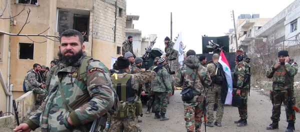 Forces loyal to the Syrian regime stand on a street with national flags after Syria's army and allied forces took full control from rebel groups of the strategic town of Salma, in the northwestern province of Latakia on January 12, 2016 - Sputnik International