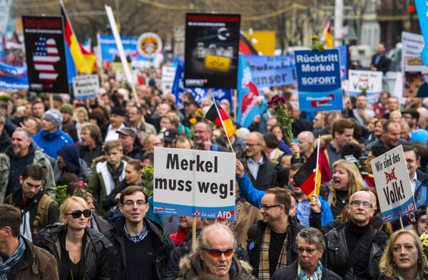 A supporter of the right-wing populist Alternative for Germany (AfD) party displays a placard showing crossed out Niqabs during a demonstration against the German government's asylum policy organized by the AfD party on November in Berlin on November 7, 2015. A supporter of the right-wing populist Alternative for Germany (AfD) party displays a placard showing crossed out Niqabs during a demonstration against the German government's asylum policy organized by the AfD party on November in Berlin on November 7, 2015. - Sputnik International
