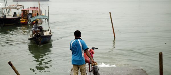 A local resident waits for a boat to cross the island during a thick blanket of haze over Port Klang on October 20, 2015 - Sputnik International