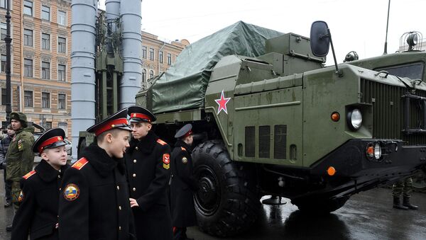 Cadets walk close to a Russian surface-to-air missile system S-300 PMU during a military exhibition marking the upcoming Defenders of the Fatherland Day holiday in Saint Petersburg on February 20, 2015 - Sputnik International