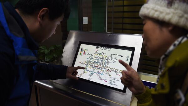 An attendant (L) explains details of new charges to a commuter in front of a subway map at a subway station in Beijing on December 29, 2014 - Sputnik International
