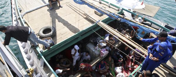In this May 12, 2013 file photo, Iranian asylum seekers who were caught in Indonesian waters while sailing to Australia, sit on a boat, at Benoa port in Bali, Indonesia - Sputnik International