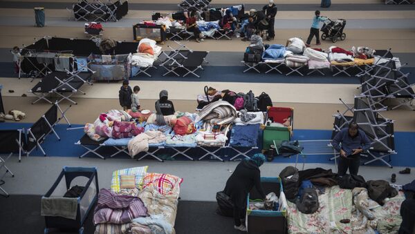 Immigrants rest on camp beds installed at the Horst Korber sports hall at the Berlin Olympic stadium complex Olympiapark on October 23, 2015 - Sputnik International