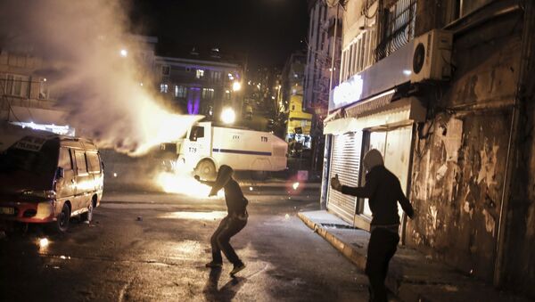Protesters run after they threw a petrol bomb against a Turkish police water cannon during clashes in Istanbul, Sunday, Feb. 14, 2016, between police forces and people protesting against security operations against Kurdish rebels in southeastern Turkey - Sputnik International