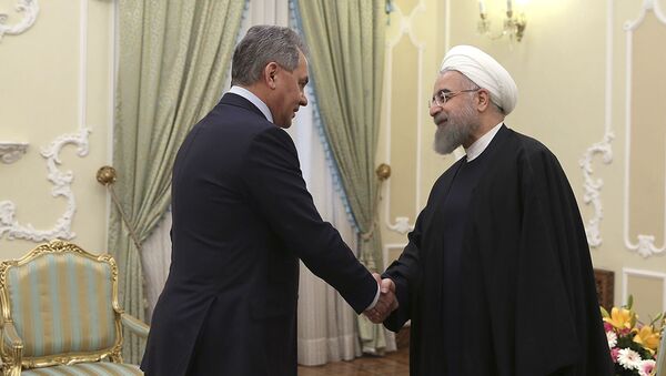 President Hassan Rouhani, right, shakes hands with Russian Defence Minister Sergei Shoigu at the start of their meeting in Tehran, Iran - Sputnik International