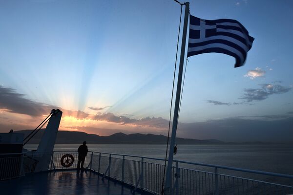 A man watches the sunrise from a ferry near the port of Piraeus on April 23, 2014. - Sputnik International