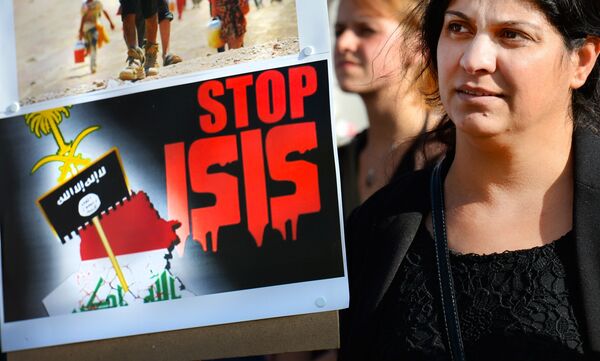 A holds a sign calling to Stop ISIS (ISIS fir Islamic State) on August 13, 2014 as she takes part in a demonstration called by Kurds in support of the Yezidis and the Christians in Iraq, in Arnhem, The Netherlands. A holds a sign calling to Stop ISIS (ISIS fir Islamic State) on August 13, 2014 as she takes part in a demonstration called by Kurds in support of the Yezidis and the Christians in Iraq, in Arnhem, The Netherlands. - Sputnik International