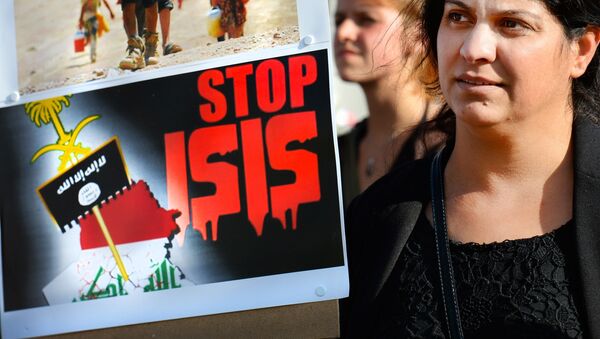 A holds a sign calling to Stop ISIS (ISIS fir Islamic State) on August 13, 2014 as she takes part in a demonstration called by Kurds in support of the Yezidis and the Christians in Iraq, in Arnhem, The Netherlands. - Sputnik International