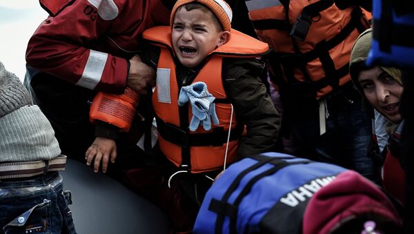 A child reacts as refugees and migrants disembark a rubber boat upon arrival at the northern island of Lesbos after crossing the Aegean sea from Turkey, in Mytilene, on February 23, 2016. - Sputnik International