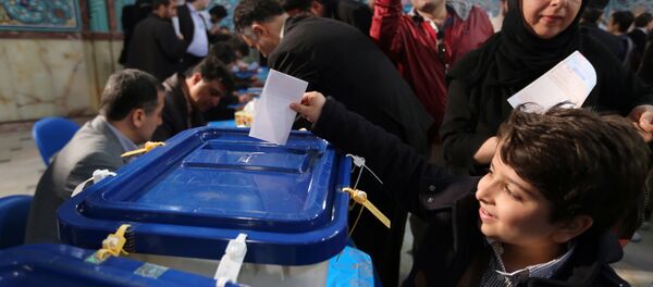 An Iranian boy casts his father ballot for both parliamentary elections and the Assembly of Experts at a polling station in Tehran on February 26, 2016 An Iranian boy casts his father ballot for both parliamentary elections and the Assembly of Experts at a polling station in Tehran on February 26, 2016 - Sputnik International