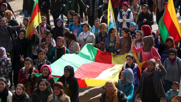Kurdish people carry flags as they march during a protest in the city of al-Derbasiyah, on the Syrian-Turkish border, against what the protesters said were the operations launched in Turkey by government security forces against the Kurds, February 9, 2016 - Sputnik International
