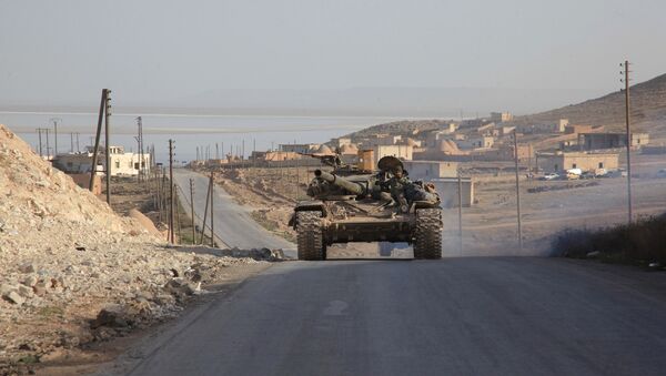 Syrian government forces drive a tank on a road during a military operation against the Islamic State (IS) group in the villages of Zarour and Khanaser, in the Aleppo governorate, on February 26, 2016 - Sputnik International