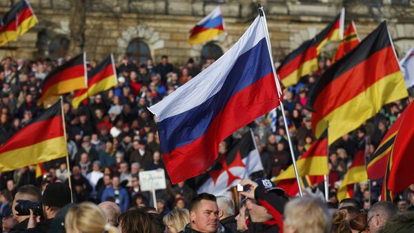 Supporters of the anti-Islam movement Patriotic Europeans Against the Islamisation of the West (PEGIDA) carry German and Russian flags during a demonstration in Dresden, Germany, February 6, 2016 - Sputnik International